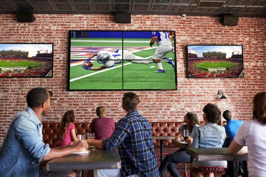 Customers watching a football game in a restaurant on a commercial AV system