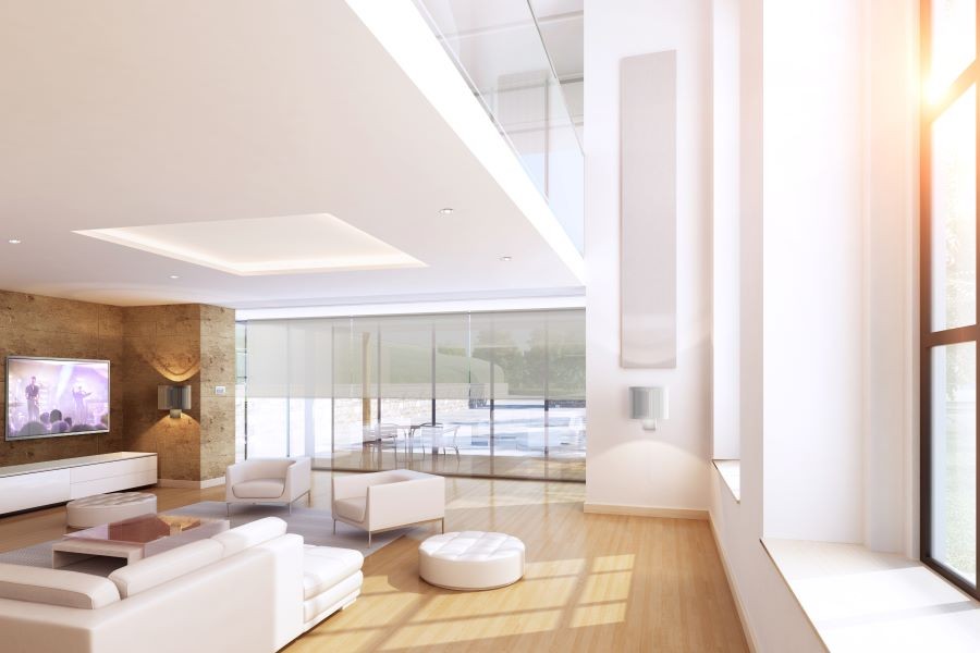 A family room with an open floor plan, TV, sunlight streaming through the windows, and shades partially lowered.